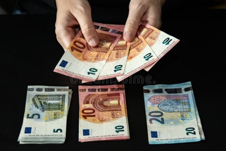 mani che impilano banconote euro lucide