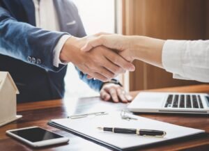 Cos’è la Surroga e Come Funziona nel Cambiare Credito in Banca 37 mani che scambiano contratti bancari in ufficio