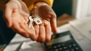 mano che scambia chiavi casa con documenti notarili