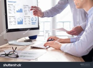 persona che consulta documenti finanziari al computer